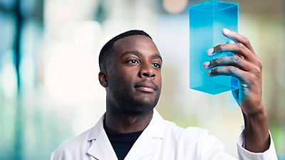 Colaborador com caixinha digital, alusiva tecnologia das embalagens Tetra Pak, em mãos